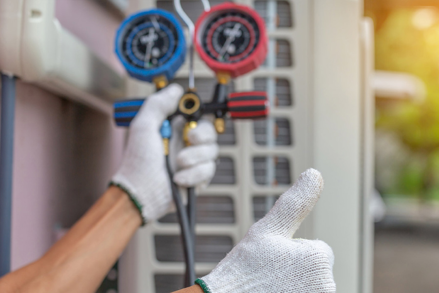 technician testing hvac unit with thumb up